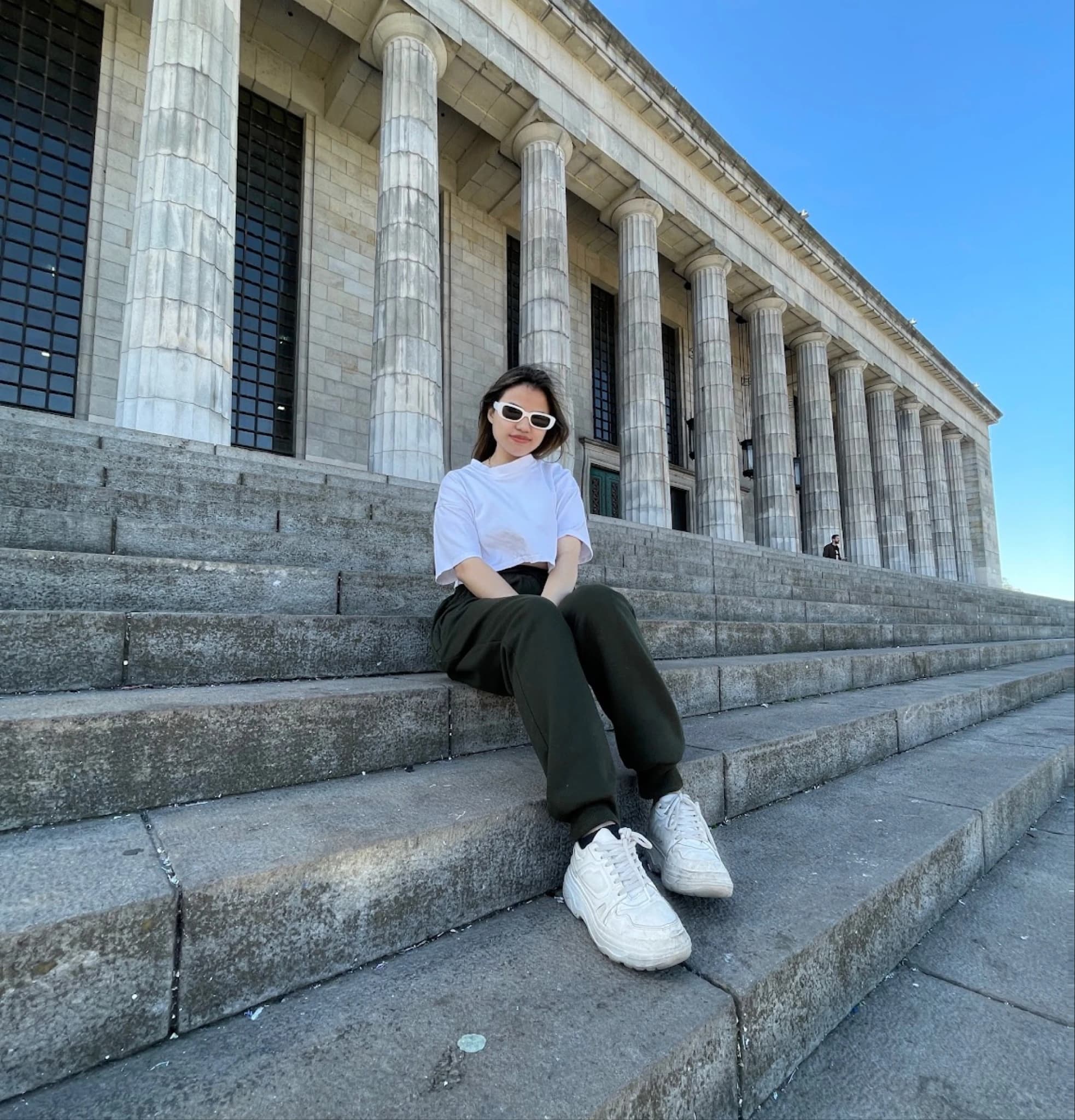 Marie Joe, founder and brand designer, sitting on stone steps