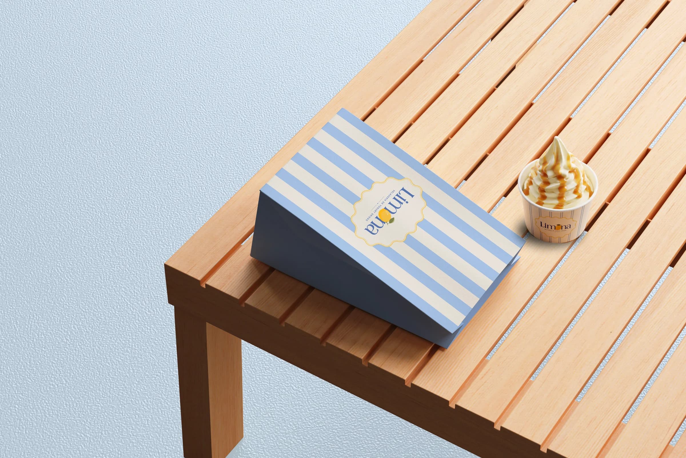 Striped Limona takeaway bag and a cup on a wooden table
